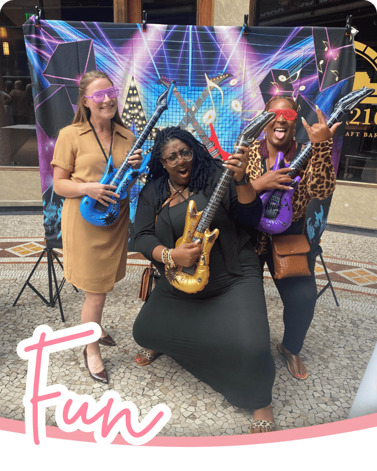 image of 3 women holding guitars in front of a concert backdrop with the word fun in pink script below